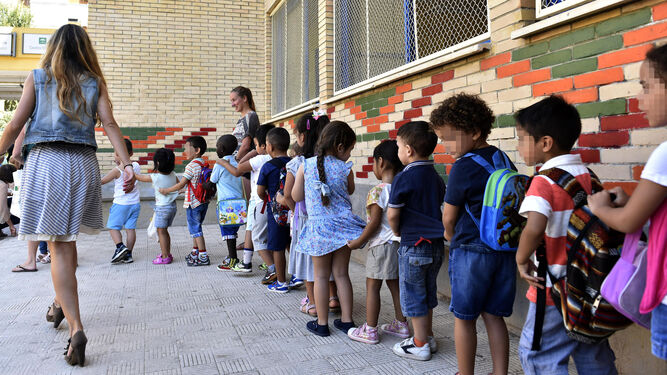 Un fila de niños en su primera día de clase en un colegio sevillano.