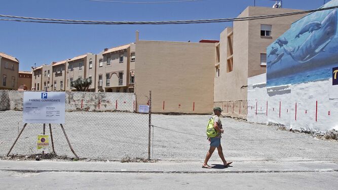 Una persona camina por el parking  de la calle Alcalde Juan Núñez en Tarifa.