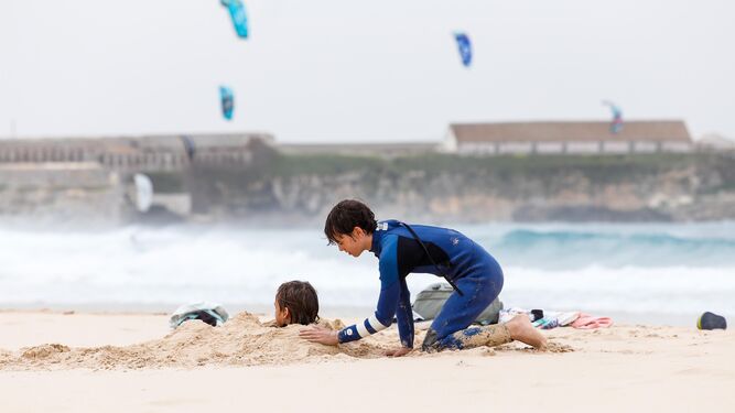 Dos niños juegan una mañana de levante de una playa de Tarifa.