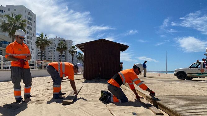 Operarios de Playas, preparando las pasarelas de madera  en Valdelagrana.